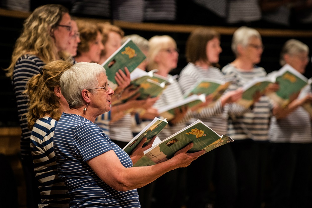 Close-up of adult choir members singing 'Ahoy!'