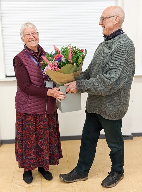 Conrad presenting Gillie with bouquet of flowers