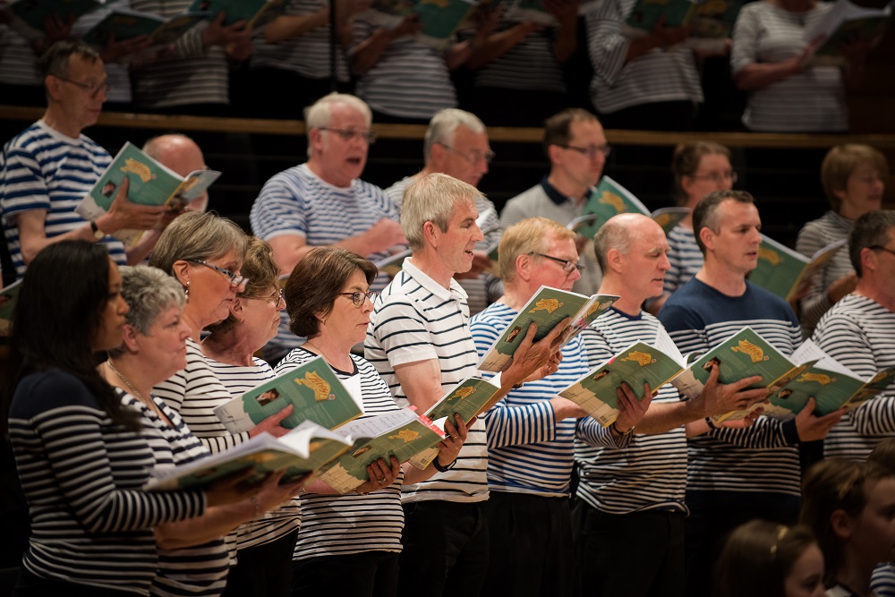 Close-up of adult choir members singing 'Ahoy!'